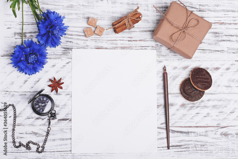 Mock up of empty paper, flower, ink pen, cakes, shuga, anise and gift on white wood desk. Flat Lay with no people. View from the top. Mock up of empty paper, flower, ink pen, cakes, shuga, anise and gift on white wood desk. Flat Lay with no people. View from the top.