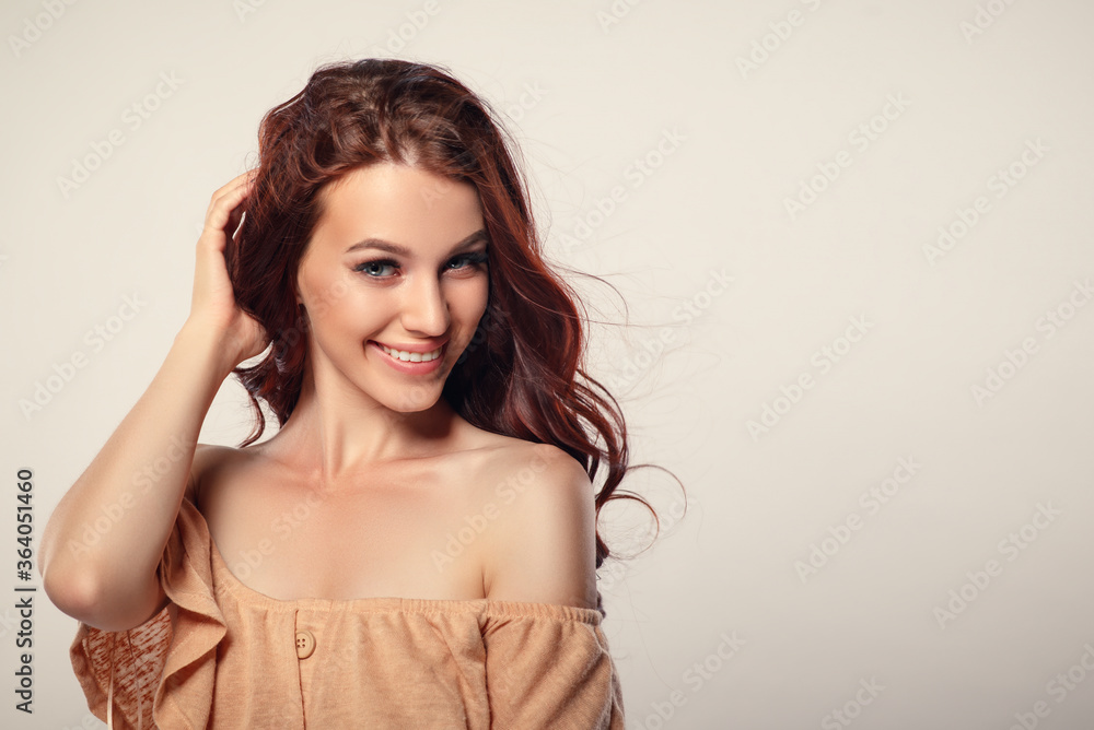 Studio glamor portrait of a beautiful woman with luxurious hair on a light background. Studio glamor portrait of a beautiful woman with luxurious hair on a light background.