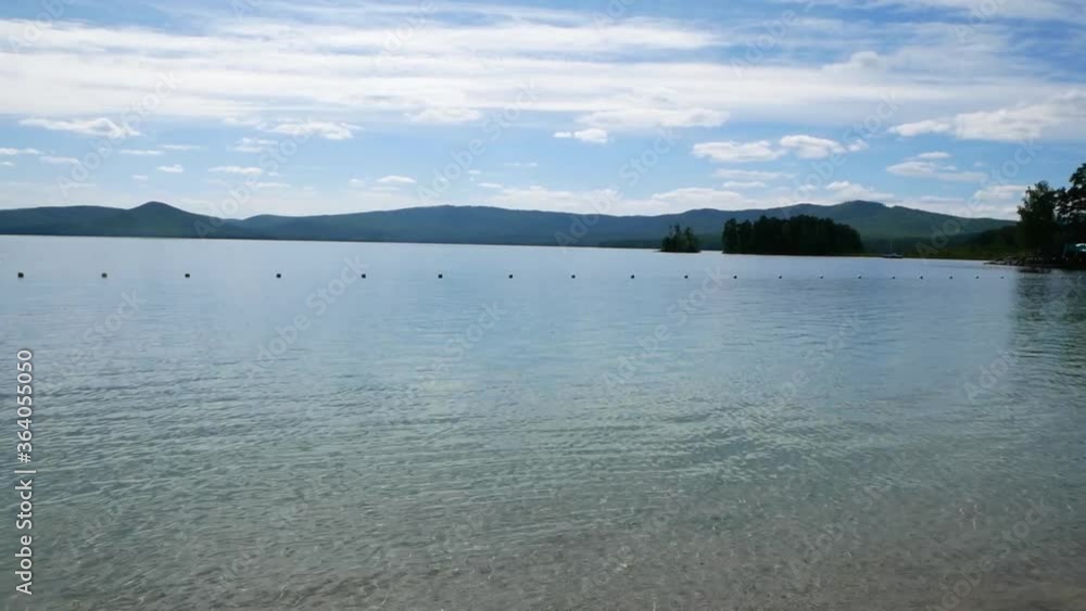 View of a lake and yacht in the distance.

Rest at the resort out of town. Water shines and shimmers in the sun.