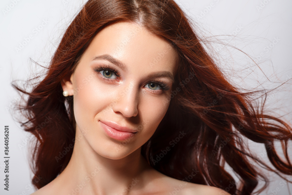 Studio glamor portrait of a beautiful woman with luxurious hair on a light background. Studio glamor portrait of a beautiful woman with luxurious hair on a light background.