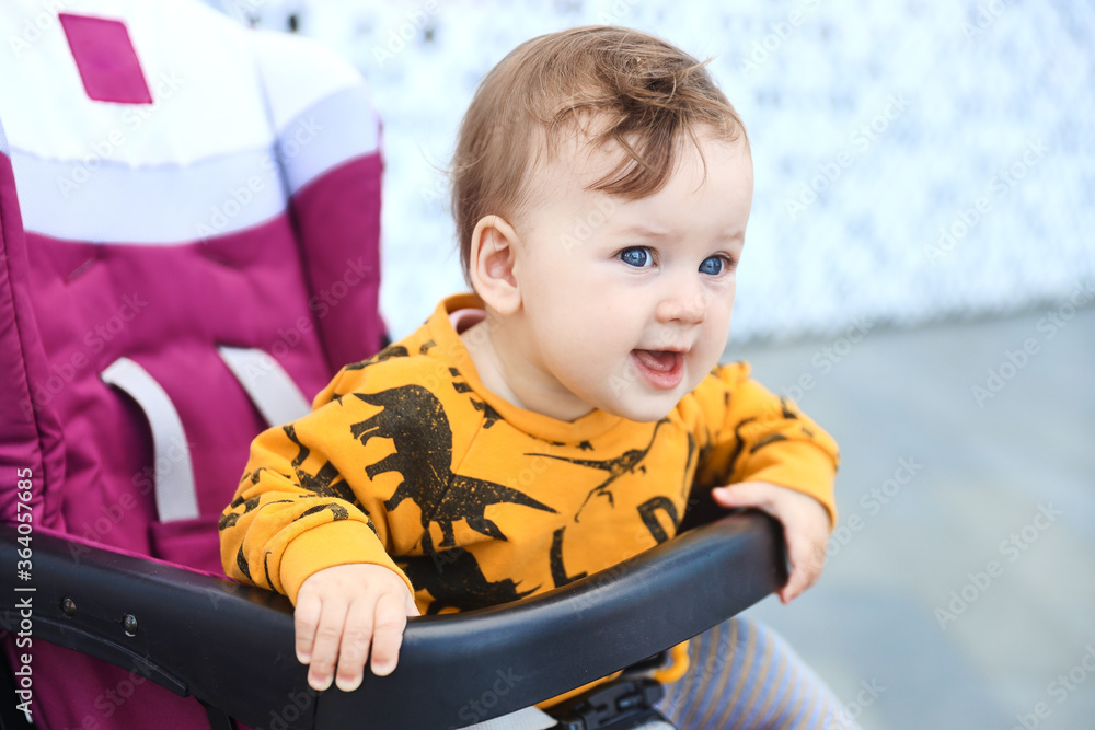 Smiling child girl on a summer walk in the pram Smiling child girl on a summer walk in the pram