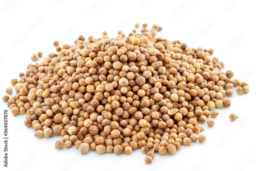 A handful of dried coriander seeds close up on a white background. Selective focus. A handful of dried coriander seeds close up on a white background. Selective focus.