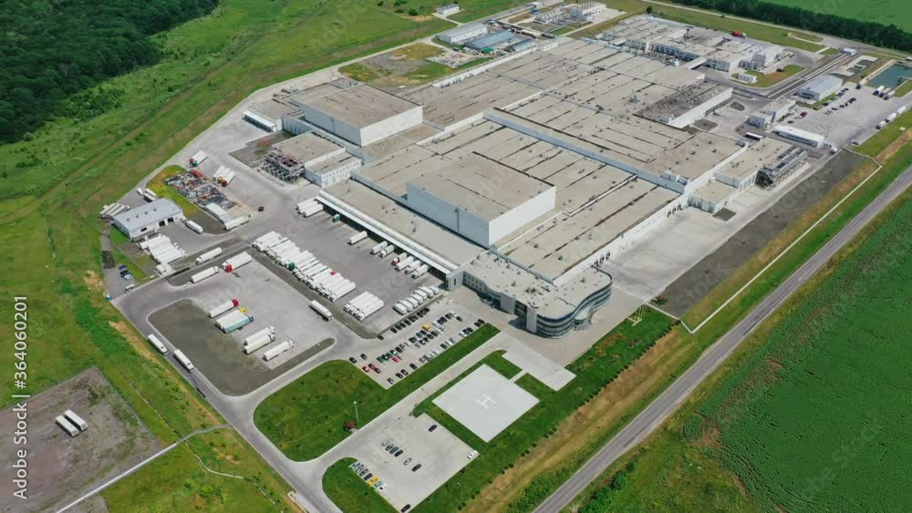 Modern industrial infrastructure. Huge production plant among green field. View from above on roofs of large buildings of industry. Aerial view. Modern industrial infrastructure. Huge production plant among green field. View from above on roofs of large buildings of industry. Aerial view.