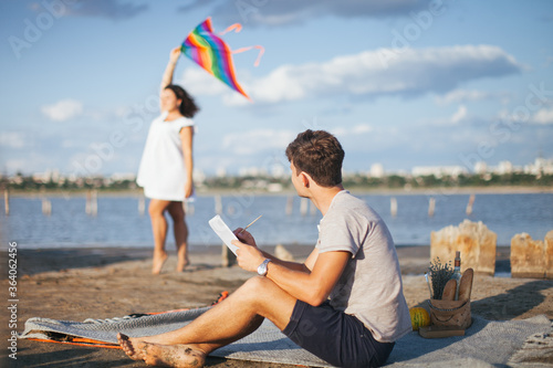 A man draws a portrait of a woman. A woman poses for an artist. Girl with a kite. LGBT people of color. LGBT flag. A beautiful girl launches a kite. © vadik02020