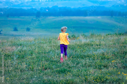 Children run across the field in summer among wildflowers, a sense of freedom, a happy childhood surrounded by nature, hiking, family holidays in the country