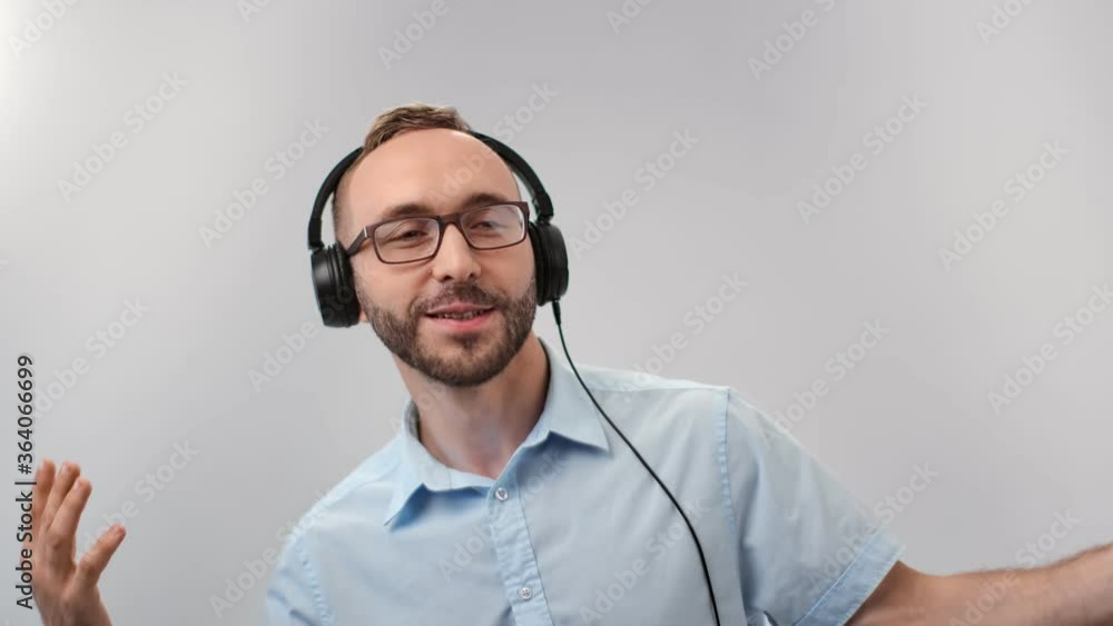 Joyful guy in headphones dancing having positive emotion. Medium close up shot on 4k RED camera Joyful guy in headphones dancing having positive emotion. Medium close up shot on 4k RED camera