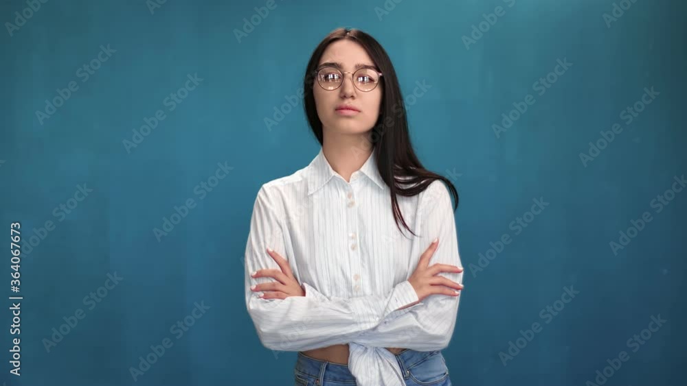 Casual mixed race female in trendy glasses posing with crossed hands. Medium shot on RED camera Casual mixed race female in trendy glasses posing with crossed hands. Medium shot on RED camera