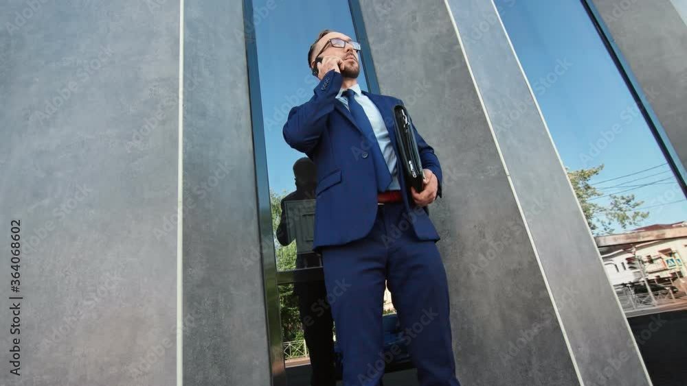 Successful businessman in suit talking use mobile outdoor. Shot on RED Raven 4k Cinema Camera Successful businessman in suit talking use mobile outdoor. Shot on RED Raven 4k Cinema Camera