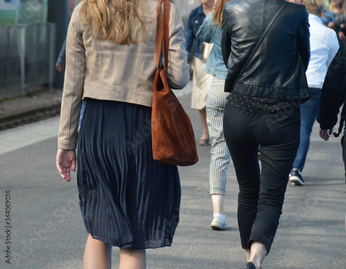 Female commuters walking as part of the crowd on the platform of a train station. Photographed in Helsinki, Finland.