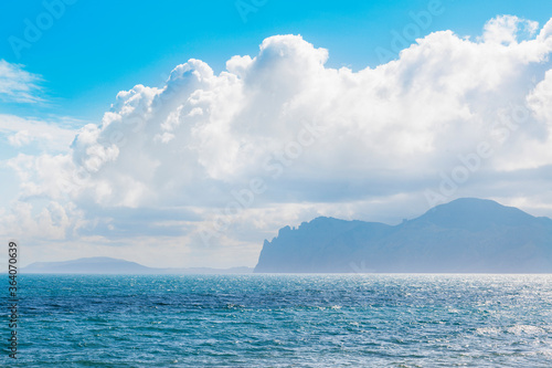 Sandy beach with mountains and cloudy sky