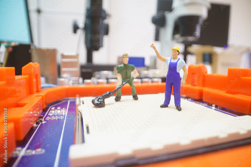 Obraz premium Miniature repair man on mainboard, Miniature figure of worker team try to repair cpu on mainboard.