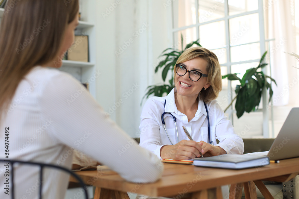 Middle aged female doctor therapist in consultation with patient in office. Middle aged female doctor therapist in consultation with patient in office.