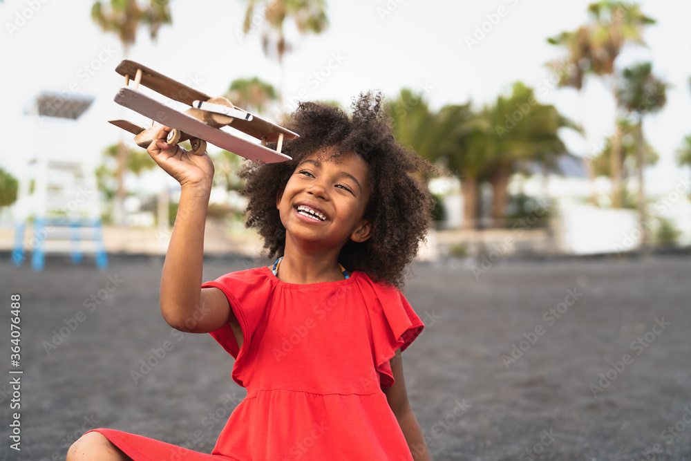 © Alessandro Biascioli - Afro child playing with wood toy airplane on the beach - Little kid having fun during summer holidays - Childhood and travel vacation concept © Alessandro Biascioli - Afro child playing with wood toy airplane on the beach - Little kid having fun during summer holidays - Childhood and travel vacation concept