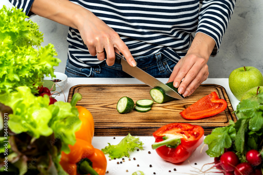 Woman cutting vegetables in the kitchen. Cooking healthy diet food concept. Woman cutting vegetables in the kitchen. Cooking healthy diet food concept.