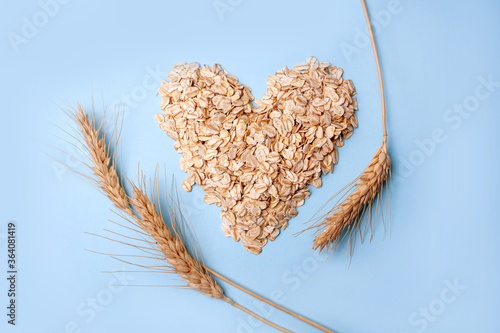 Heart-shaped oatmeal and wheat on a blue background. Flat Lay Style