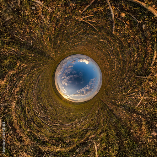 Inversion of little planet transformation of spherical panorama 360 degrees. Spherical abstract aerial view in field with awesome beautiful clouds. Curvature of space.