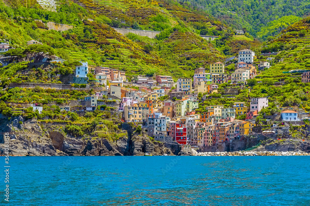 A view from the sea towards the Cinque Terre coast and the village of Riomaggiore, Italy in the summertime