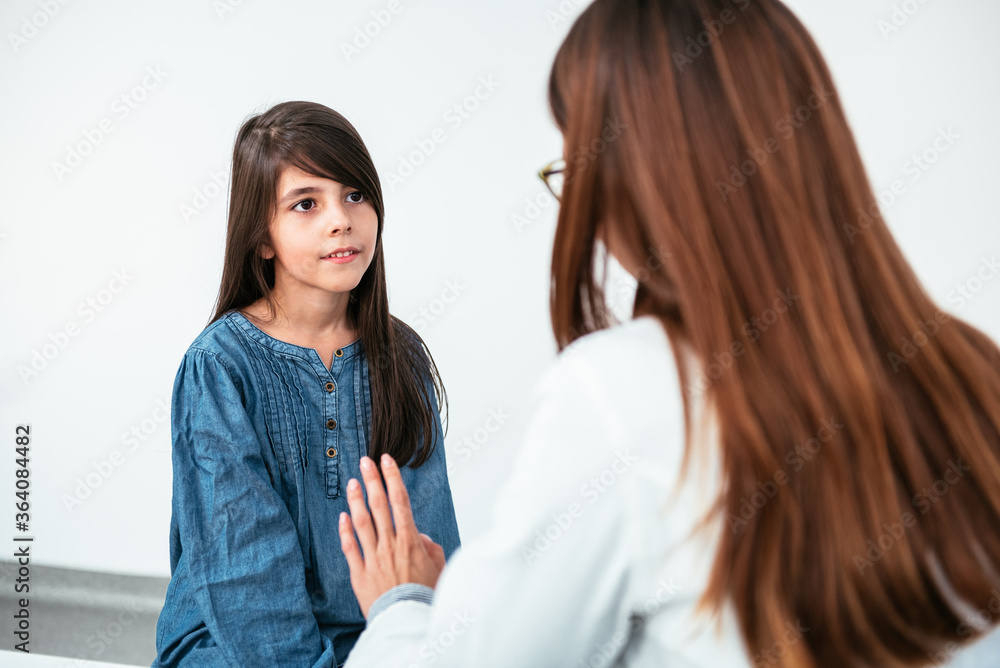 Doctor psychotherapist, therapist or pediatrician in white coat listens teen girl during reception at clinic. Teen problems, therapy session, adolescent medicine pediatrician concept Doctor psychotherapist, therapist or pediatrician in white coat listens teen girl during reception at clinic. Teen problems, therapy session, adolescent medicine pediatrician concept