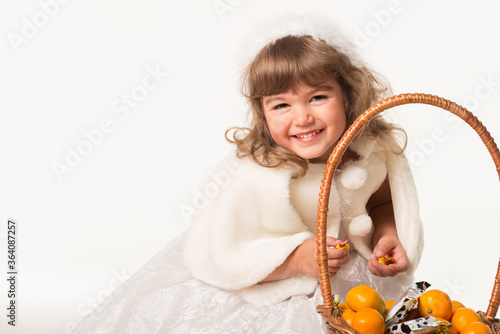 Adorable little girl holding mandarin oranges.