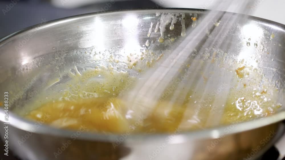 Close-up shot of professional chef mixing eggs and butter with whisk in a bowl. 4K Close-up shot of professional chef mixing eggs and butter with whisk in a bowl. 4K