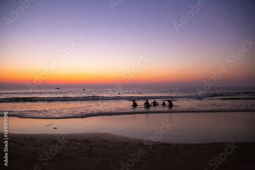 Idyllic landscape with teenagers (childs of tourists from England ) at Wonderful sunset on the Nirvana beach in South India in Kumta region . Unrecognizable persons . 