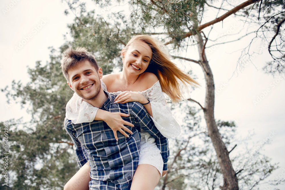 Cute couple in a park. Lady in a white dress. Guy in a blue shirt Cute couple in a park. Lady in a white dress. Guy in a blue shirt