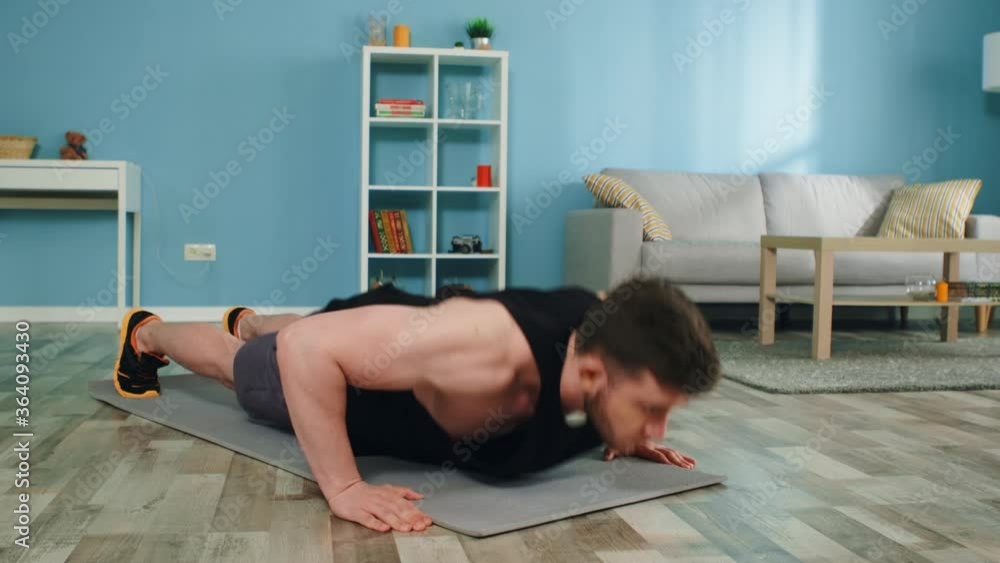 Young man is doing push-ups at home, workouting in the morning, enjoying sport, strong and motivated, does his best to achieve his goal, Slow motion. Young man is doing push-ups at home, workouting in the morning, enjoying sport, strong and motivated, does his best to achieve his goal, Slow motion.