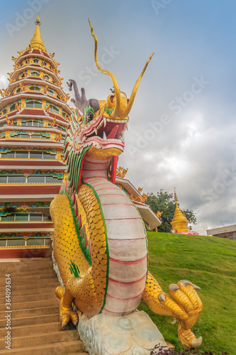 Yellow dragon head at Wat Huay Pla Kang, bublic Chinese temple in Chiang Rai Province, Thailand with dramatic blue sky background. photo