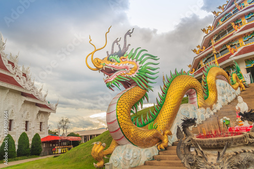 Yellow dragon head at Wat Huay Pla Kang, bublic Chinese temple in Chiang Rai Province, Thailand with dramatic blue sky background. © kampwit