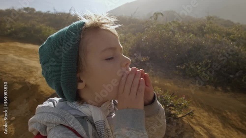 Portrait of child shouting outdoors, call for anybody in mountains alone, screams loud in volcano vent. Travel concept. Healthy lifestyle.