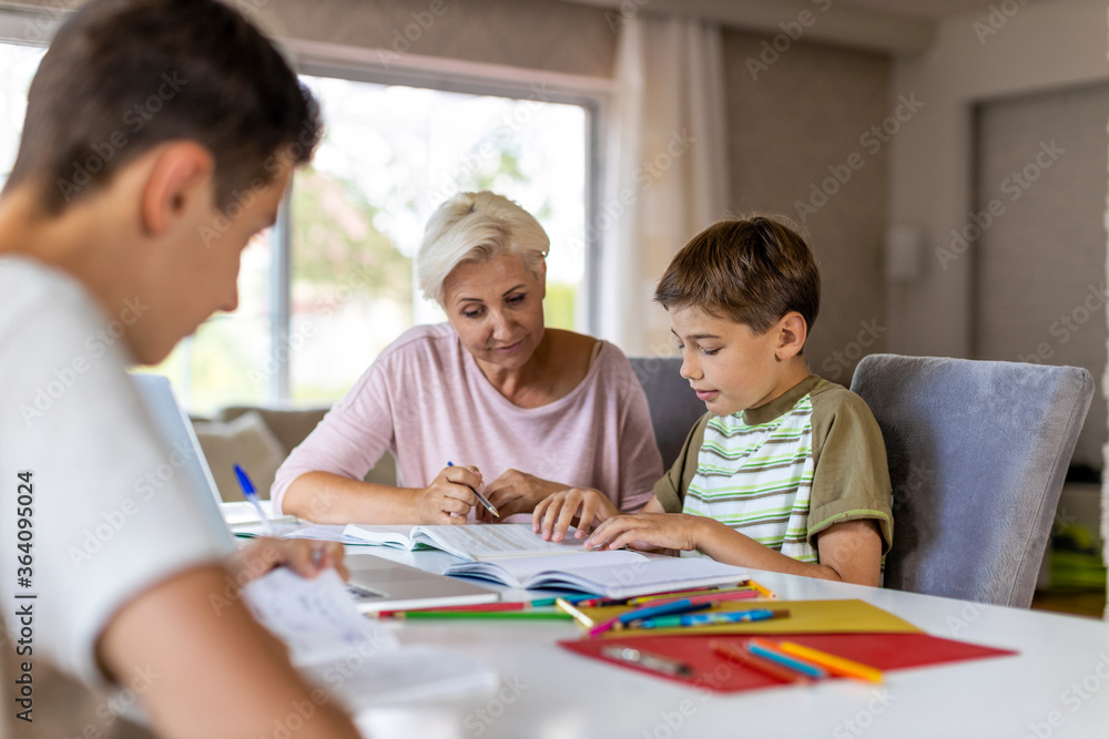 Mother helping her kids doing homework at home
Mother helping her kids doing homework at home