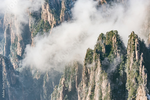 Clouds by the mountain peaks of Huangshan National park at sunrise time.