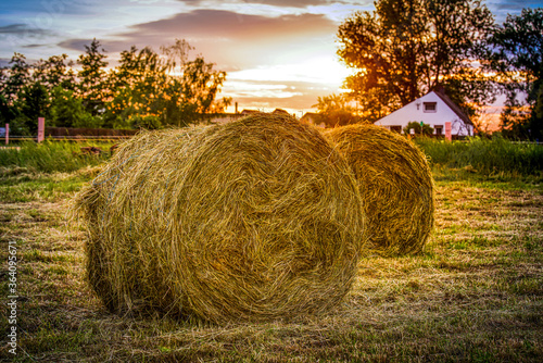 Strohballen auf einem Feld mit Sonnenuntergang photo