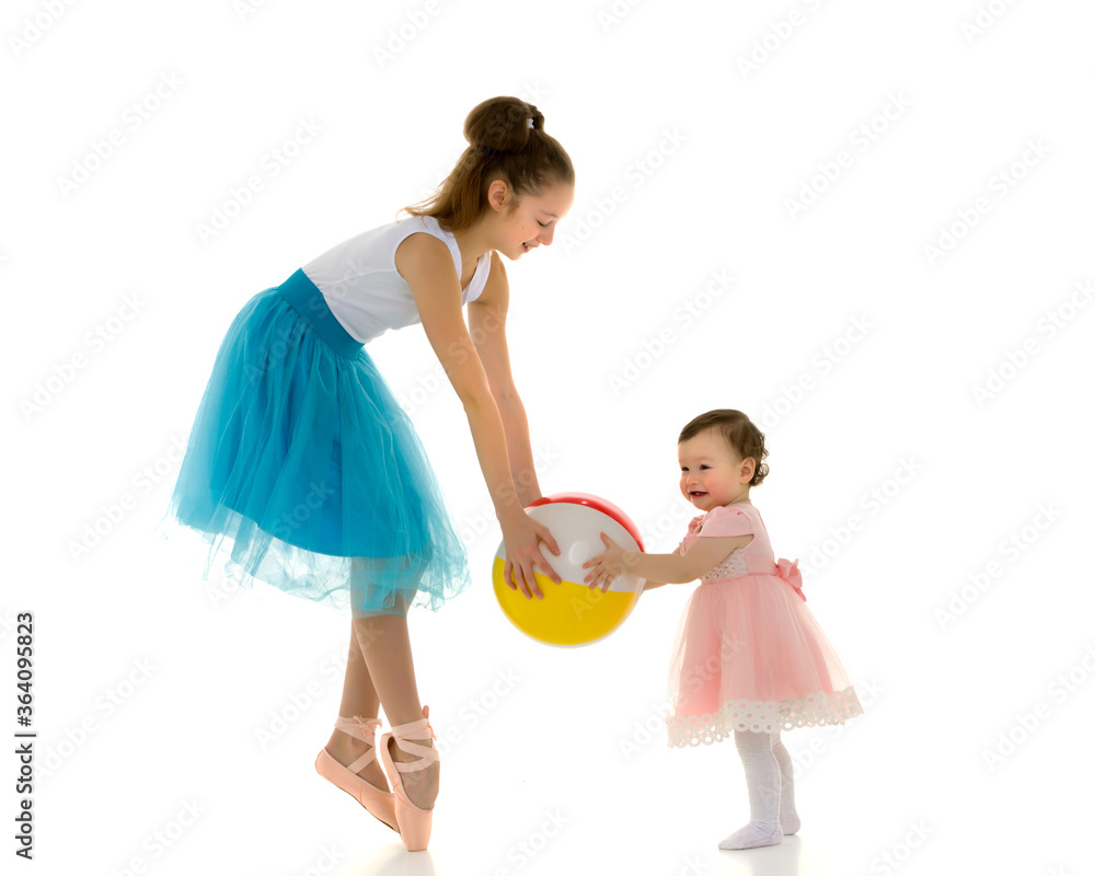 Graceful Ballerina Playing Ball with Adorable Smiling Toddler Girl. Graceful Ballerina Playing Ball with Adorable Smiling Toddler Girl.