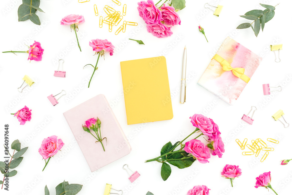 Frame composition with notebook, eucalyptus, gift and roses on white background. Flat lay Frame composition with notebook, eucalyptus, gift and roses on white background. Flat lay
