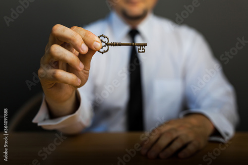 Key to success in businessman hand on background of the sky.
