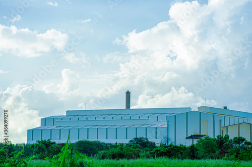 Industry factory buidling with modern warehouse in blue sky clouds background. Environmentally friendly manufacturing plant of new technology production line