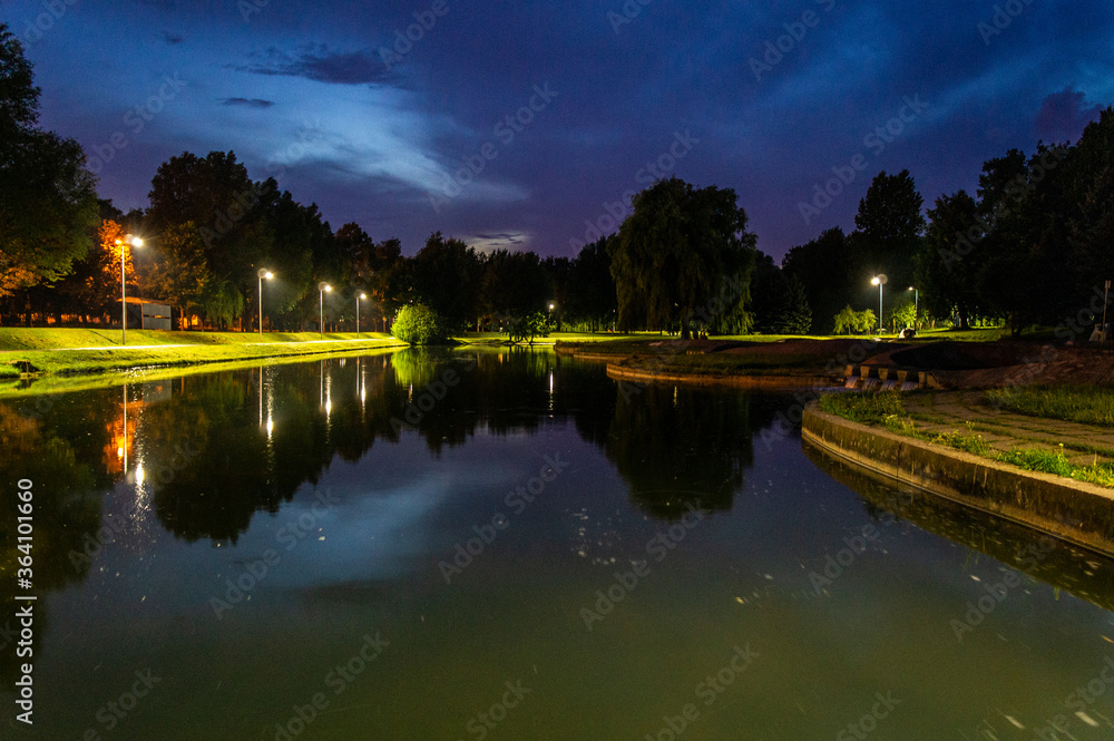 Night summer European park with river and promenade