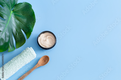 Spa composition on a colored background with a Monstera leaf