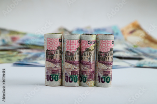 Doha, Qatar - May 03, 2020: Currencies and money exchange trading concepts. Qatari 500 ,100,50,10,5,1 Riyals Bank Note .& Coins ,Qatari Currency roll . photo