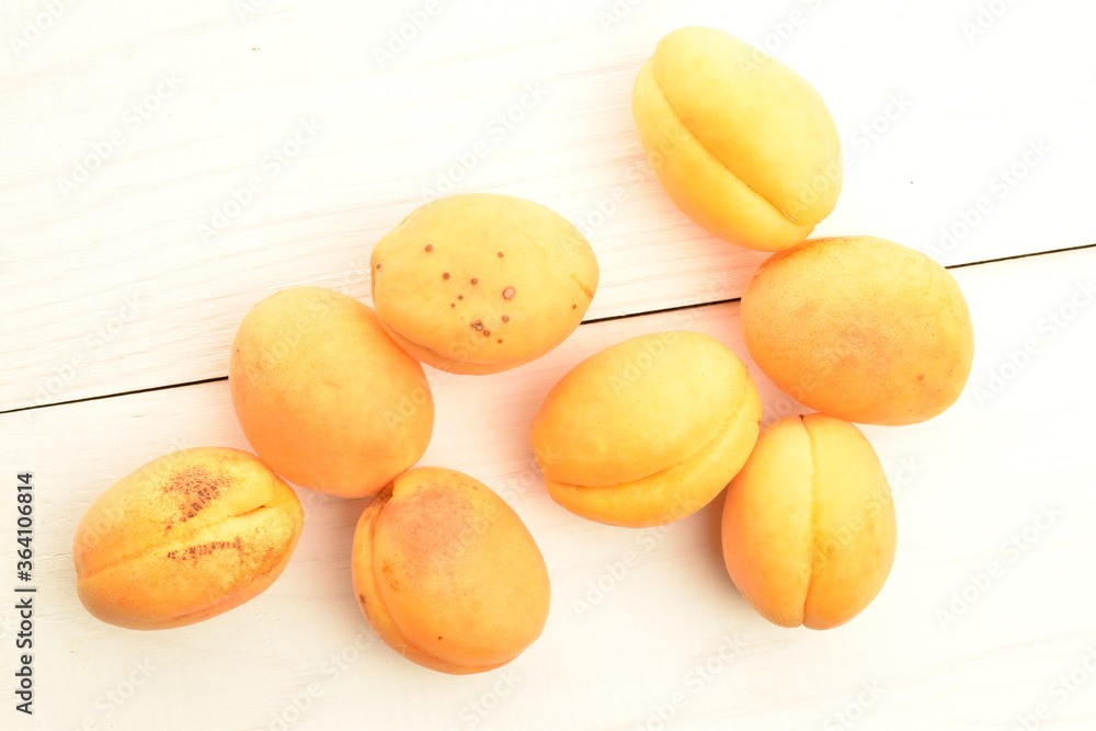Ripe organic yellow apricot, close-up, on a wooden table. Ripe organic yellow apricot, close-up, on a wooden table.
