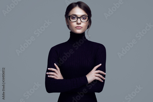 Cute student girl wearing black turtleneck sweater and stylish eyeglasses
