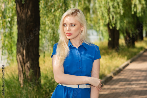 Fototapeta Naklejka Na Ścianę i Meble -  Portrait of a beautiful blonde girl outdoors in summer