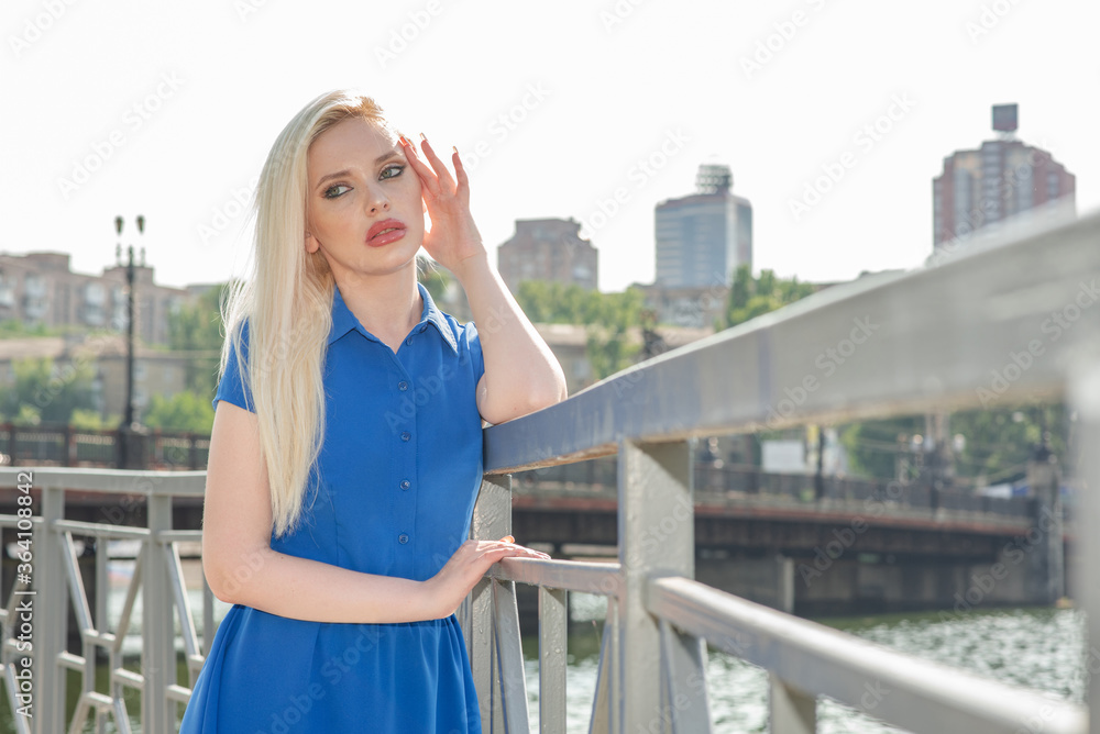 Portrait of a beautiful blonde girl outdoors in summer