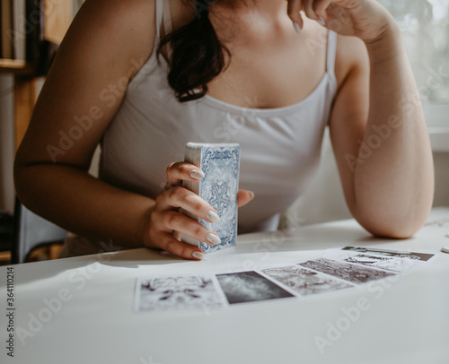 woman holding in her hands tarot cards