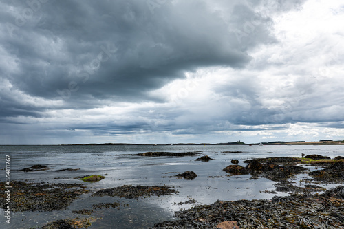 The tide has turned at Low Newton-by-the-Sea but clouds are heavy before the rain on a warm summers day.