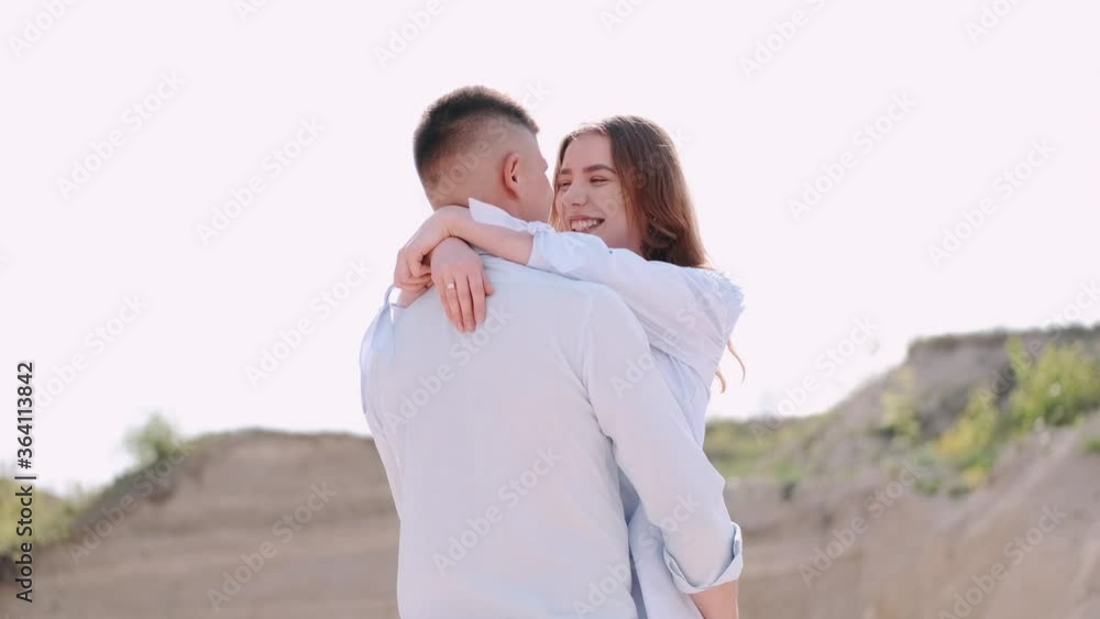 Man holds woman. People have romantic date in career. Young adults spend time outside together. Man holds woman. People have romantic date in career. Young adults spend time outside together.