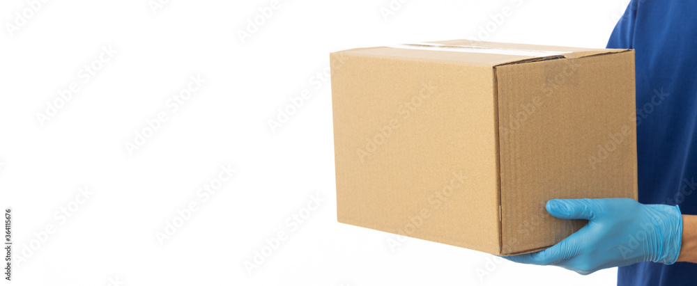 Closeup delivery man hand in medical gloves holding cardboard box isolated on white banner background, Packaging mockup, Delivery service concept.