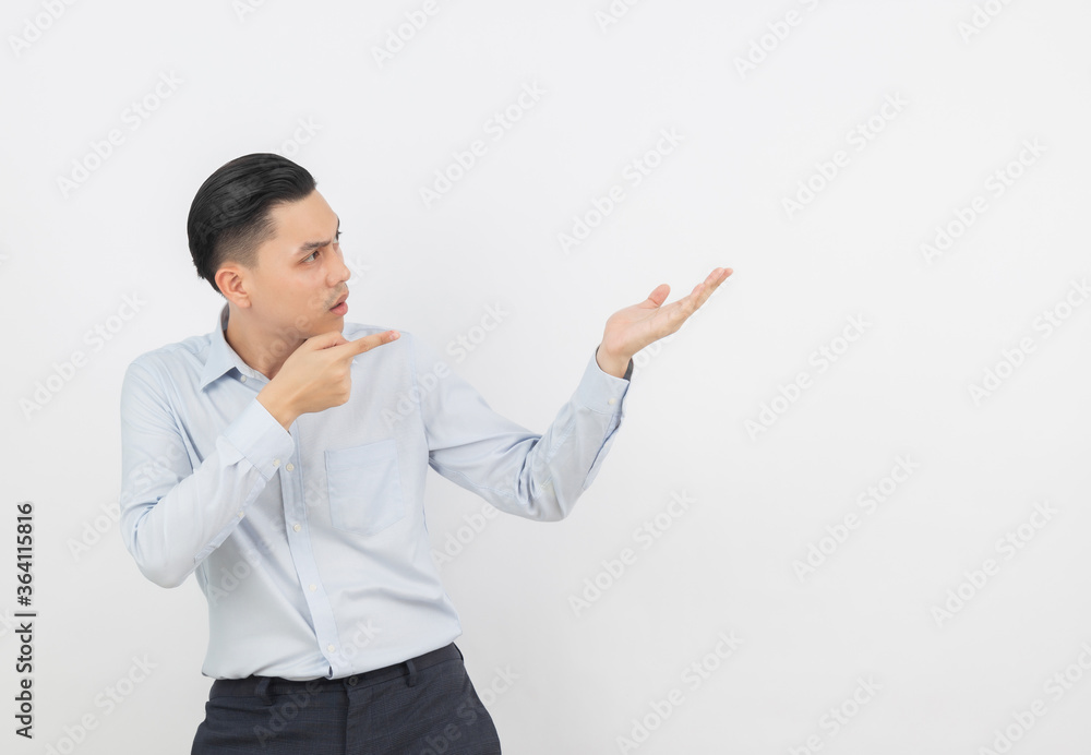 Young asian business man with blue shirt pointing to the side with a hand to present a product or an idea isolated on white background. Young asian business man with blue shirt pointing to the side with a hand to present a product or an idea isolated on white background.