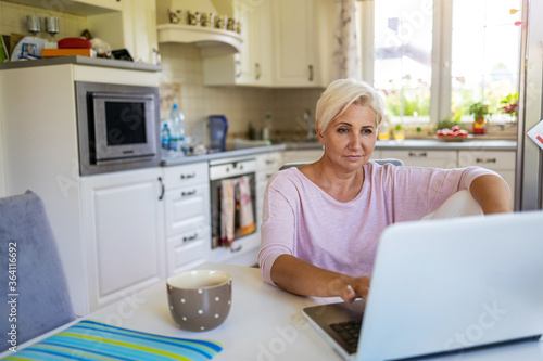 Mature woman using laptop at home
